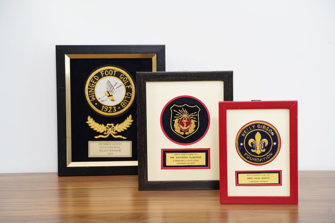 Framed bullion crests with engraved presentation plates